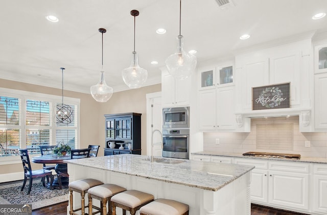 kitchen with ornamental molding, appliances with stainless steel finishes, dark wood-style flooring, and decorative backsplash