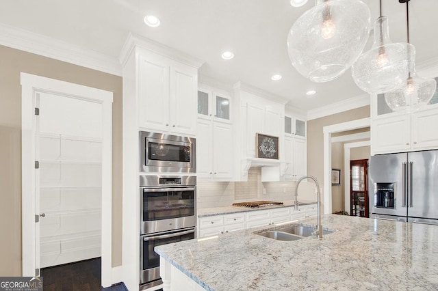 kitchen with light stone counters, stainless steel appliances, tasteful backsplash, glass insert cabinets, and a sink