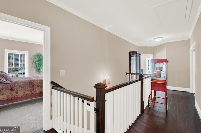 corridor with crown molding, attic access, dark wood-type flooring, an upstairs landing, and baseboards