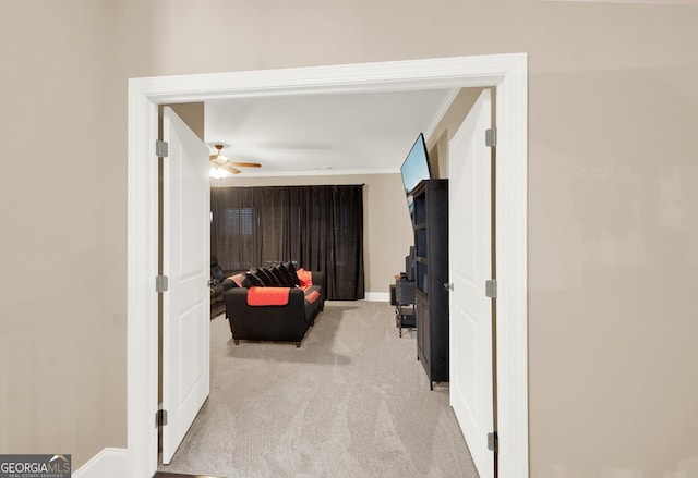 hall featuring crown molding, carpet, and baseboards