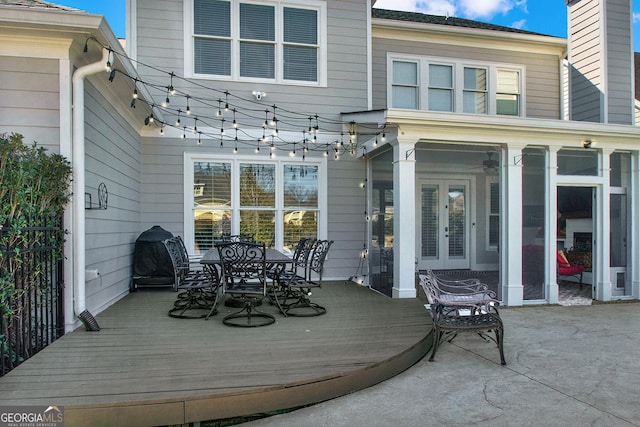 deck with french doors and outdoor dining area