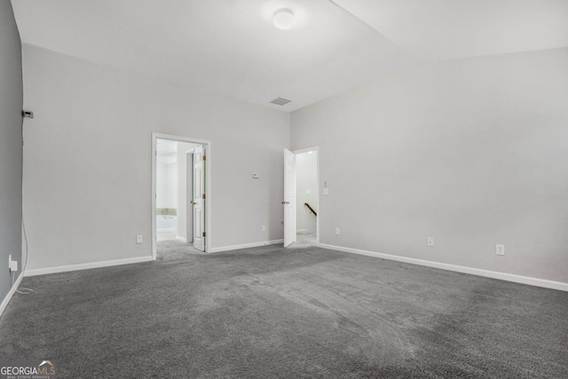 carpeted empty room with lofted ceiling, visible vents, and baseboards