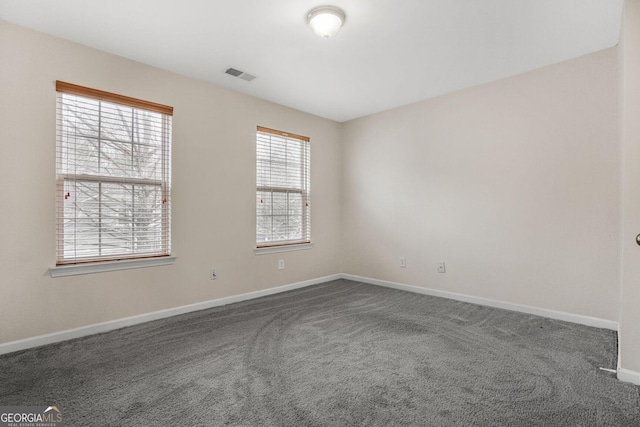 empty room featuring carpet floors, visible vents, and baseboards