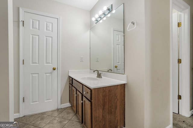 bathroom with vanity, baseboards, and tile patterned floors