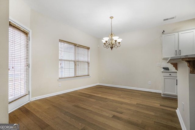 unfurnished dining area with dark wood-style floors, baseboards, and visible vents