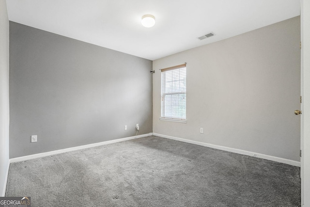 carpeted spare room with visible vents and baseboards