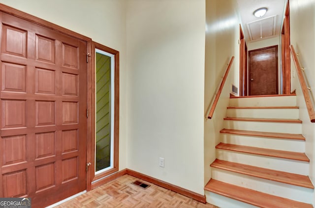 entrance foyer with stairs, visible vents, and baseboards