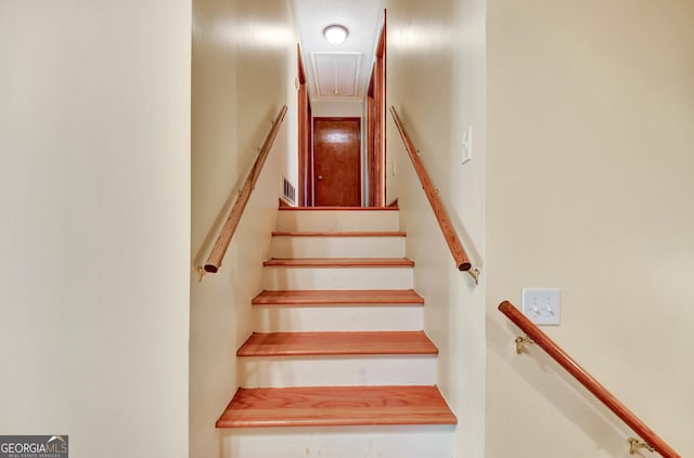 staircase featuring attic access and visible vents