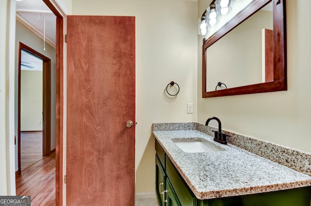 bathroom featuring wood finished floors, vanity, and baseboards