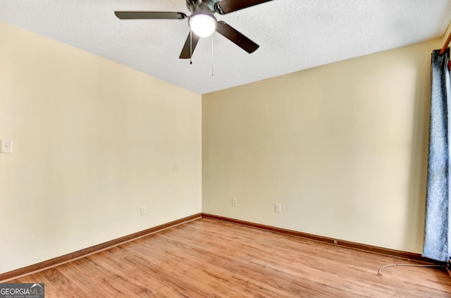 spare room with a textured ceiling, a ceiling fan, light wood-style flooring, and baseboards