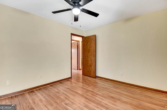 unfurnished room featuring baseboards, a ceiling fan, and light wood-style floors