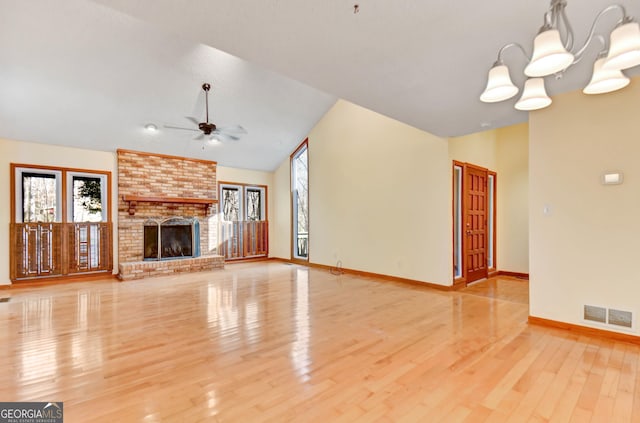 unfurnished living room with a wealth of natural light, visible vents, a fireplace, and ceiling fan