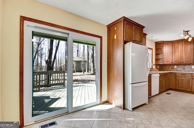 kitchen featuring light tile patterned floors, white appliances, visible vents, open shelves, and tasteful backsplash