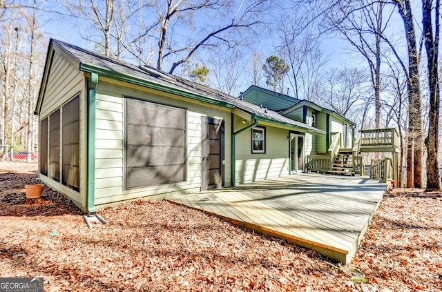 exterior space with a deck, driveway, and an attached garage