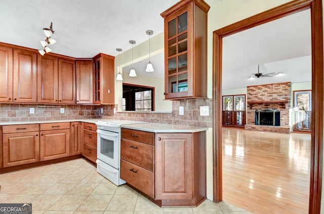 kitchen featuring pendant lighting, white electric range oven, decorative backsplash, glass insert cabinets, and ceiling fan