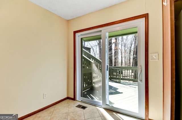 doorway to outside featuring visible vents, baseboards, and light tile patterned floors