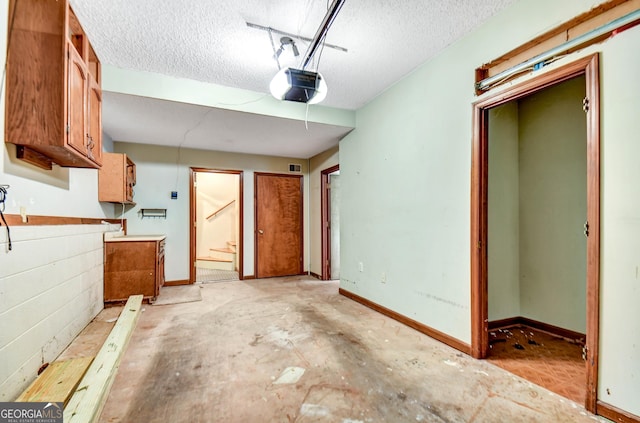 kitchen with baseboards, brown cabinets, and a textured ceiling