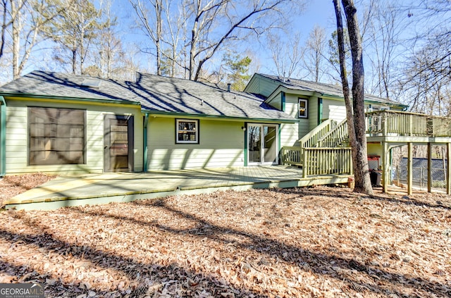 back of property featuring a patio area, a shingled roof, and a deck