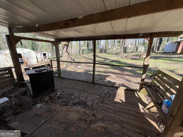 deck with an outdoor structure, fence, and a shed