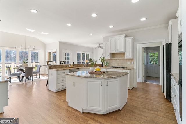 kitchen featuring backsplash, white cabinets, gas cooktop, light wood-type flooring, and a peninsula