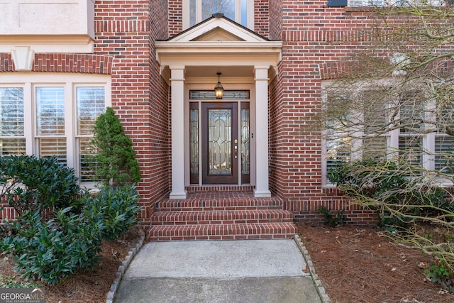 doorway to property featuring brick siding