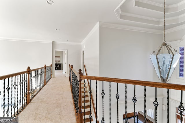 hallway featuring carpet, crown molding, recessed lighting, a raised ceiling, and an upstairs landing