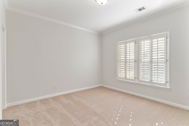 empty room with baseboards, carpet flooring, visible vents, and crown molding