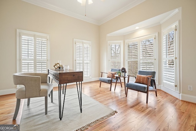 living area with light wood-style flooring, baseboards, ceiling fan, and crown molding