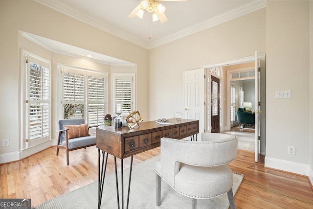 office space with ornamental molding, light wood-type flooring, baseboards, and a ceiling fan