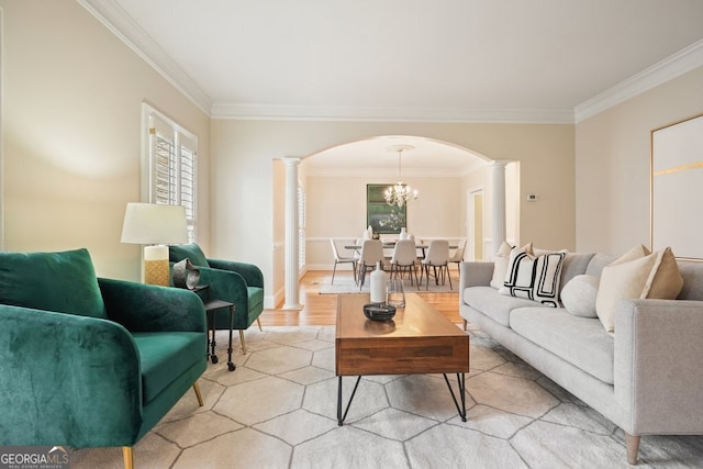 living area featuring arched walkways, a notable chandelier, ornamental molding, light wood-type flooring, and decorative columns