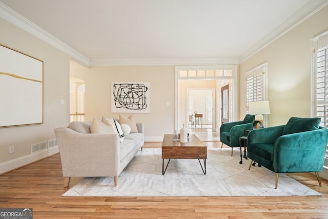 living room featuring visible vents, arched walkways, crown molding, and wood finished floors