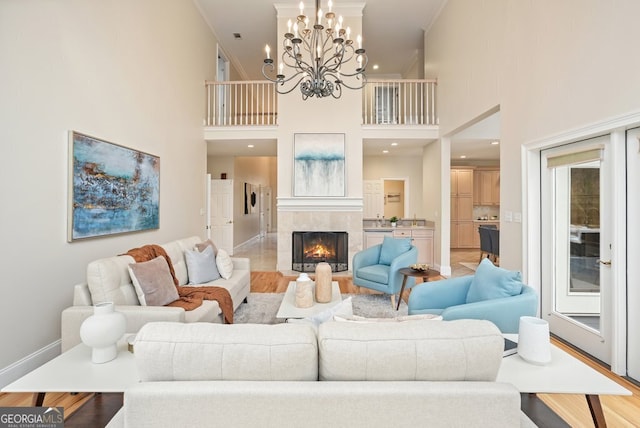 living room featuring light wood finished floors, ornamental molding, and a tiled fireplace