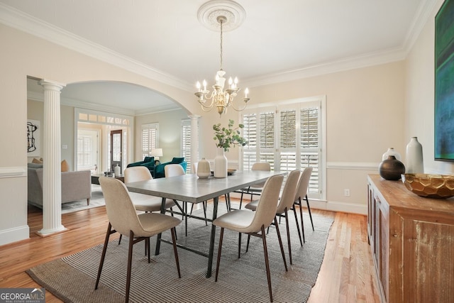 dining area with ornate columns, light wood finished floors, and a wealth of natural light