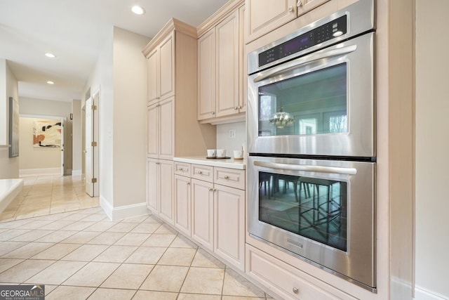 kitchen with light tile patterned floors, double oven, cream cabinetry, and recessed lighting