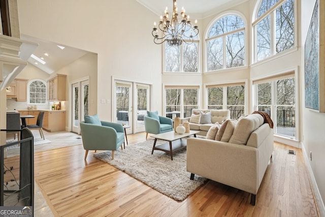 living room featuring light wood finished floors, french doors, and plenty of natural light