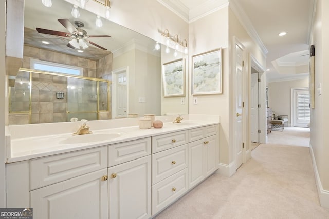 bathroom featuring double vanity, ornamental molding, a sink, and a shower stall