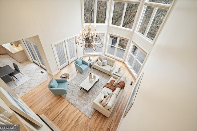 living area featuring an inviting chandelier, a high ceiling, and wood finished floors