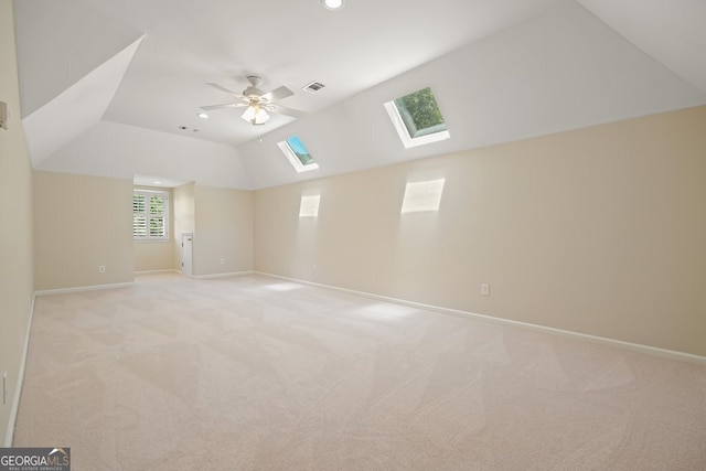 additional living space with recessed lighting, light colored carpet, a ceiling fan, vaulted ceiling, and baseboards