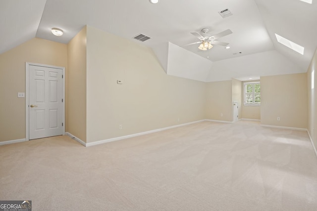 bonus room featuring baseboards, vaulted ceiling with skylight, visible vents, and light colored carpet