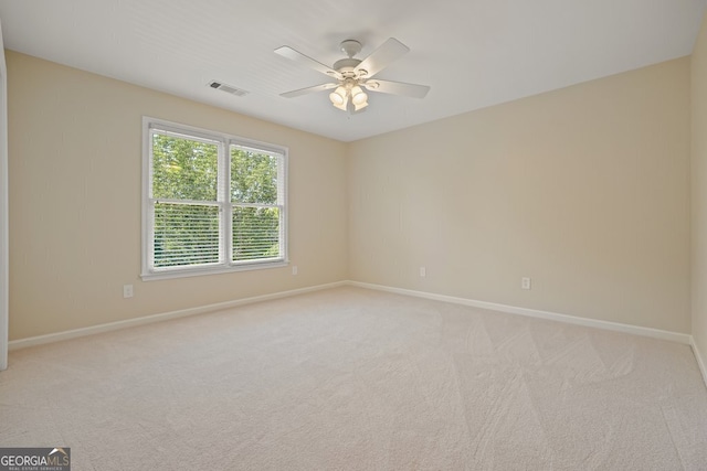 empty room with ceiling fan, baseboards, visible vents, and light colored carpet