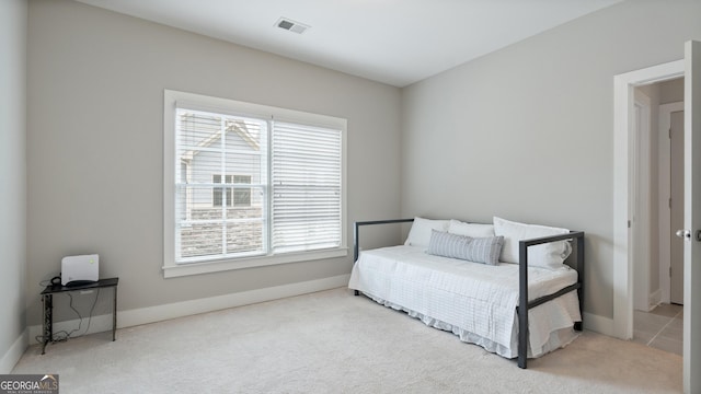 carpeted bedroom featuring visible vents, baseboards, and multiple windows