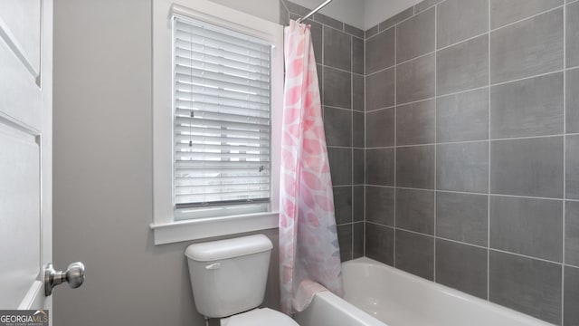 bathroom featuring toilet and shower / bath combo with shower curtain