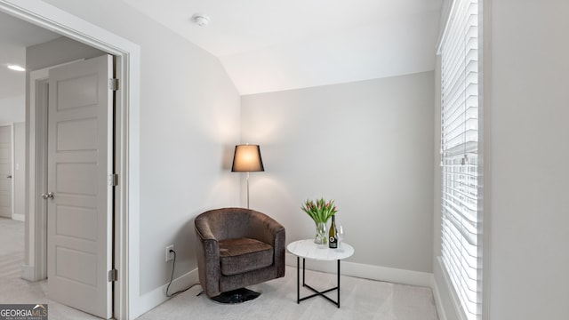 living area with carpet floors, baseboards, and vaulted ceiling