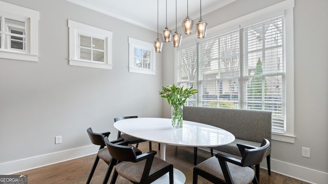 dining space with dark wood-type flooring, baseboards, and an inviting chandelier