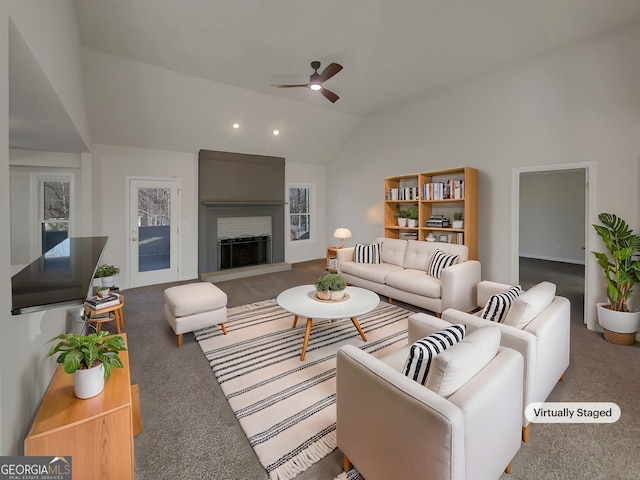 living room with a ceiling fan, lofted ceiling, a large fireplace, and carpet