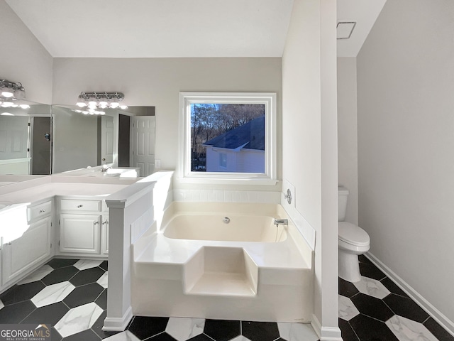 bathroom featuring toilet, baseboards, a bath, and vanity