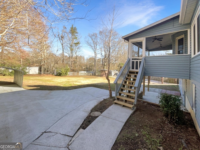 view of patio with stairs, fence, and a sunroom