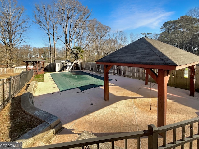 view of swimming pool with a fenced in pool, a patio, a fenced backyard, a water slide, and a gazebo