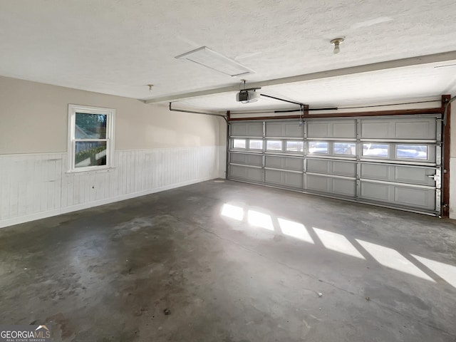 garage featuring wainscoting and a garage door opener