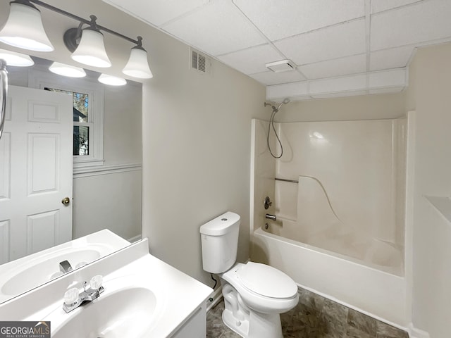 bathroom featuring visible vents, a drop ceiling, toilet,  shower combination, and vanity